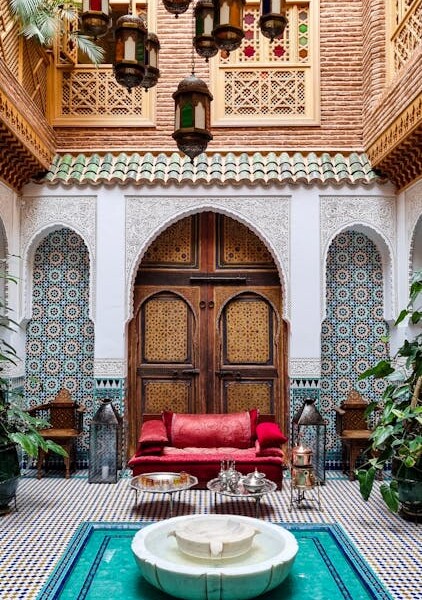 Traditional Moroccan riad courtyard with turquoise fountain and red seating