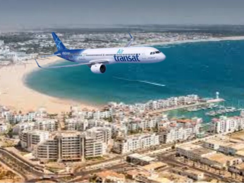 Air Transat airplane flying over Agadir beach and coastal city architecture