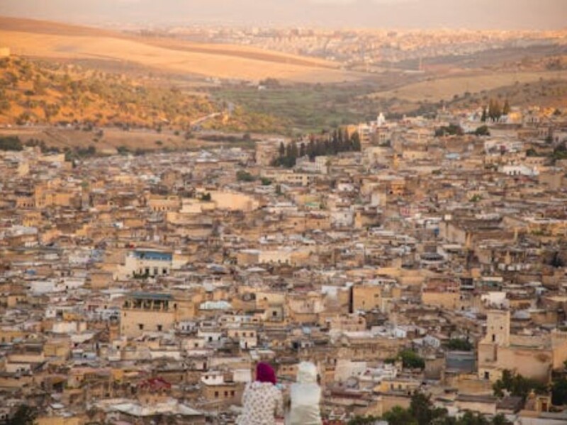 Aerial view of historic Moroccan medina with golden stone buildings and valley