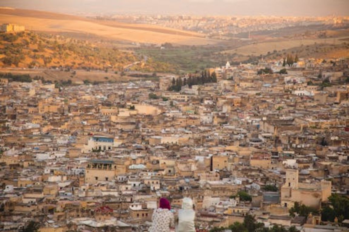 Aerial view of historic Moroccan medina with golden stone buildings and valley