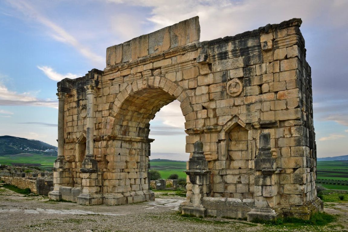 # Alt Text Volubilis Roman arch ruins Morocco ancient stone gateway landscape