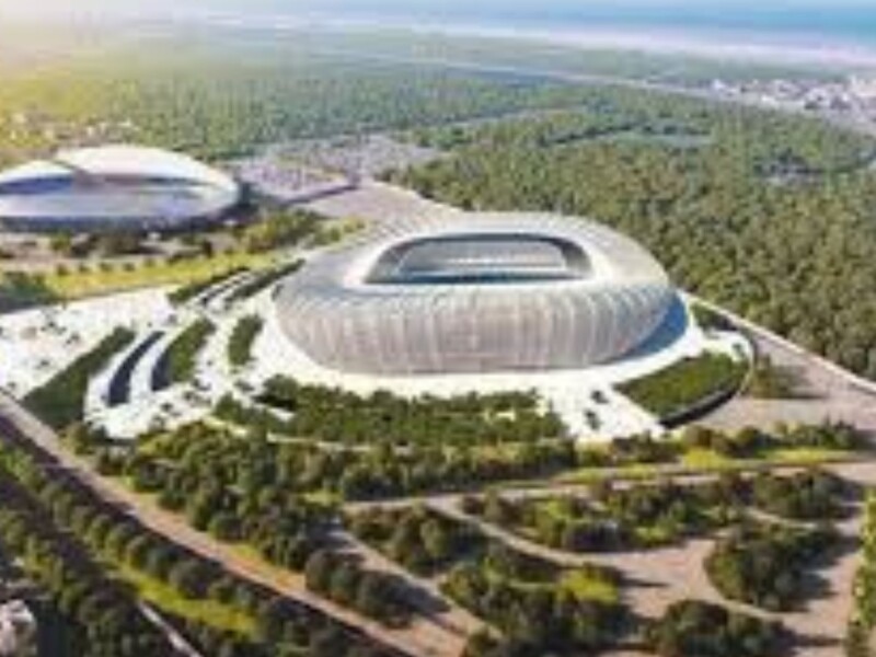 Aerial view of modern stadium complex in forested Morocco landscape