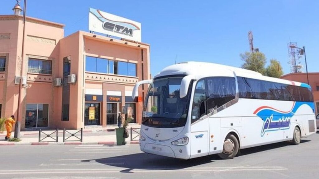 Daytime photo of the CTM station in Chefchaouen showing a white CTM coach bus parked in front of the station building under a clear blue sky, illustrating the city’s main long-distance transport hub.